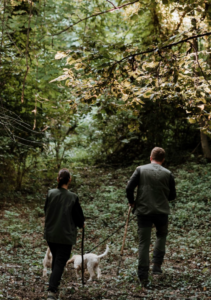 two people exploring nature with their dogs