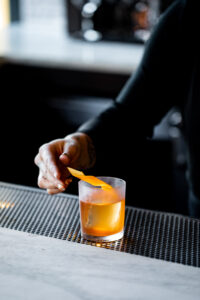 a bartender garnishing an Old Fashioned