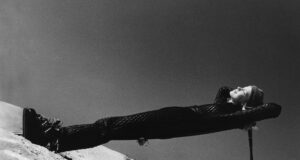 Former Olympic Skier Suzy Chaffee wearing black quilted ski suit. Credit: Isi Veleris, Glamour, ©Condé Nast