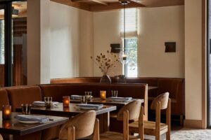 Dining room at our restaurant in Aspen, Colorado featuring tables with a mix of chairs and booths, all decorated in brown tones.