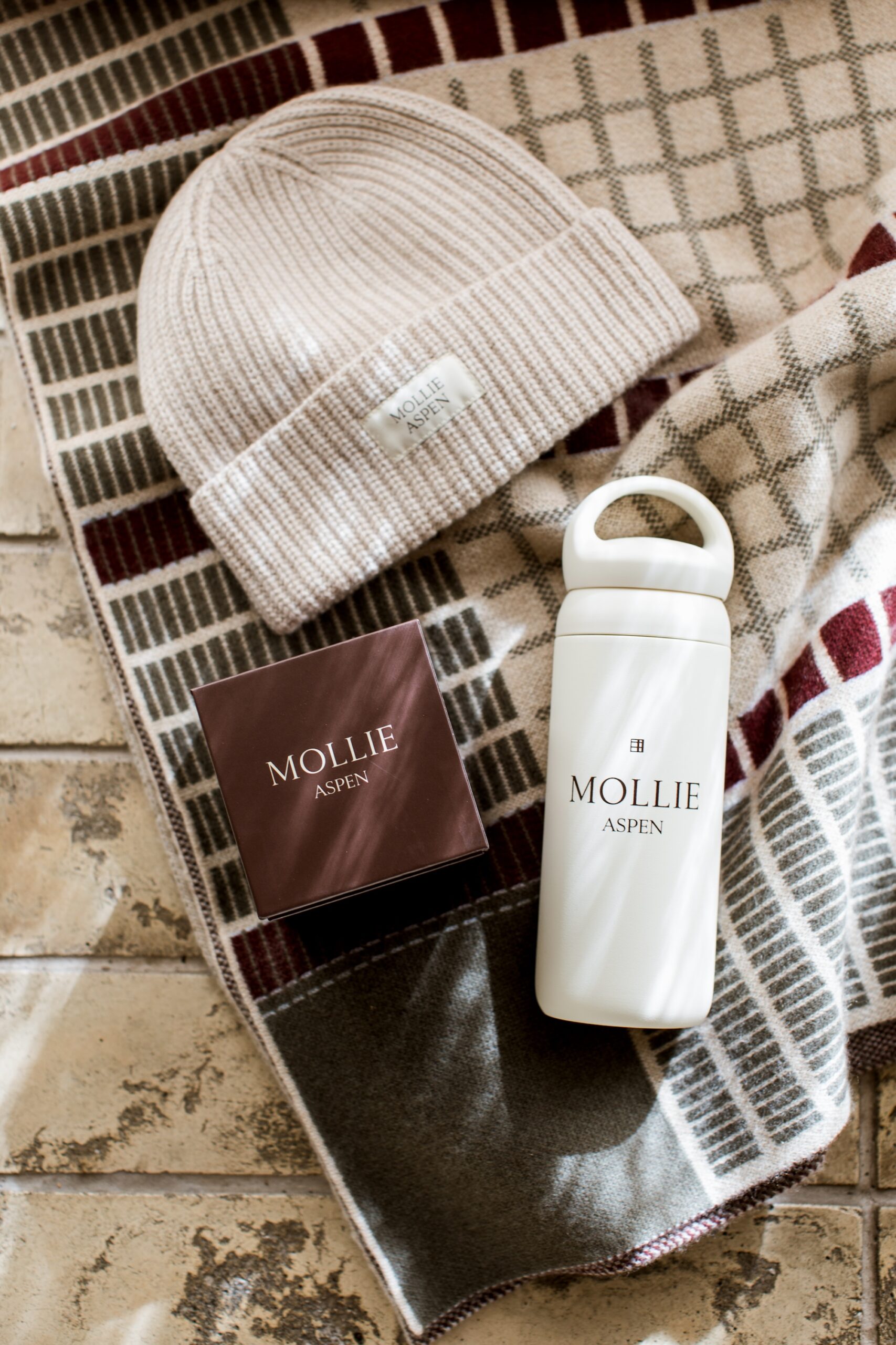 Cashmere beanie, candle, water bottle and throw blanket from MOLLIE retail boutique