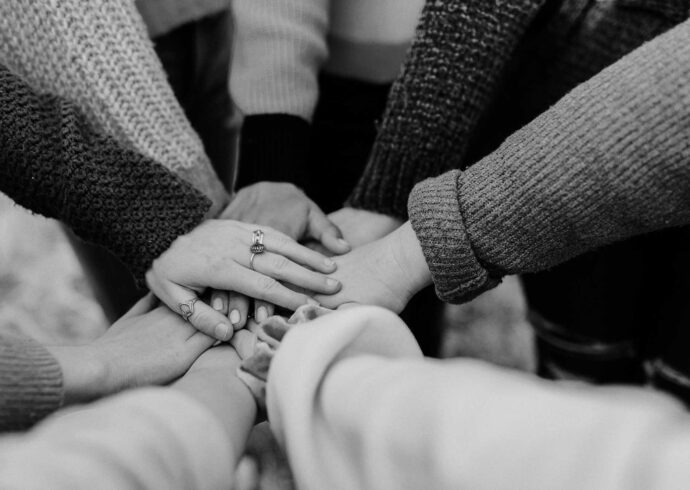 A diverse group of women with their hands together in a circle