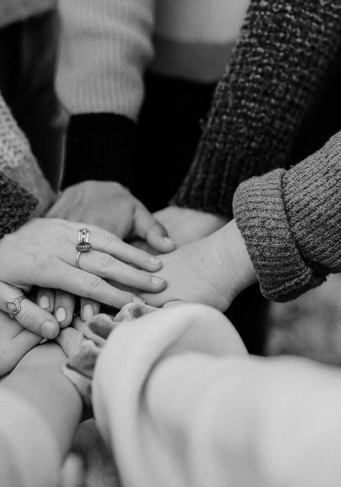 A diverse group of women with their hands together in a circle