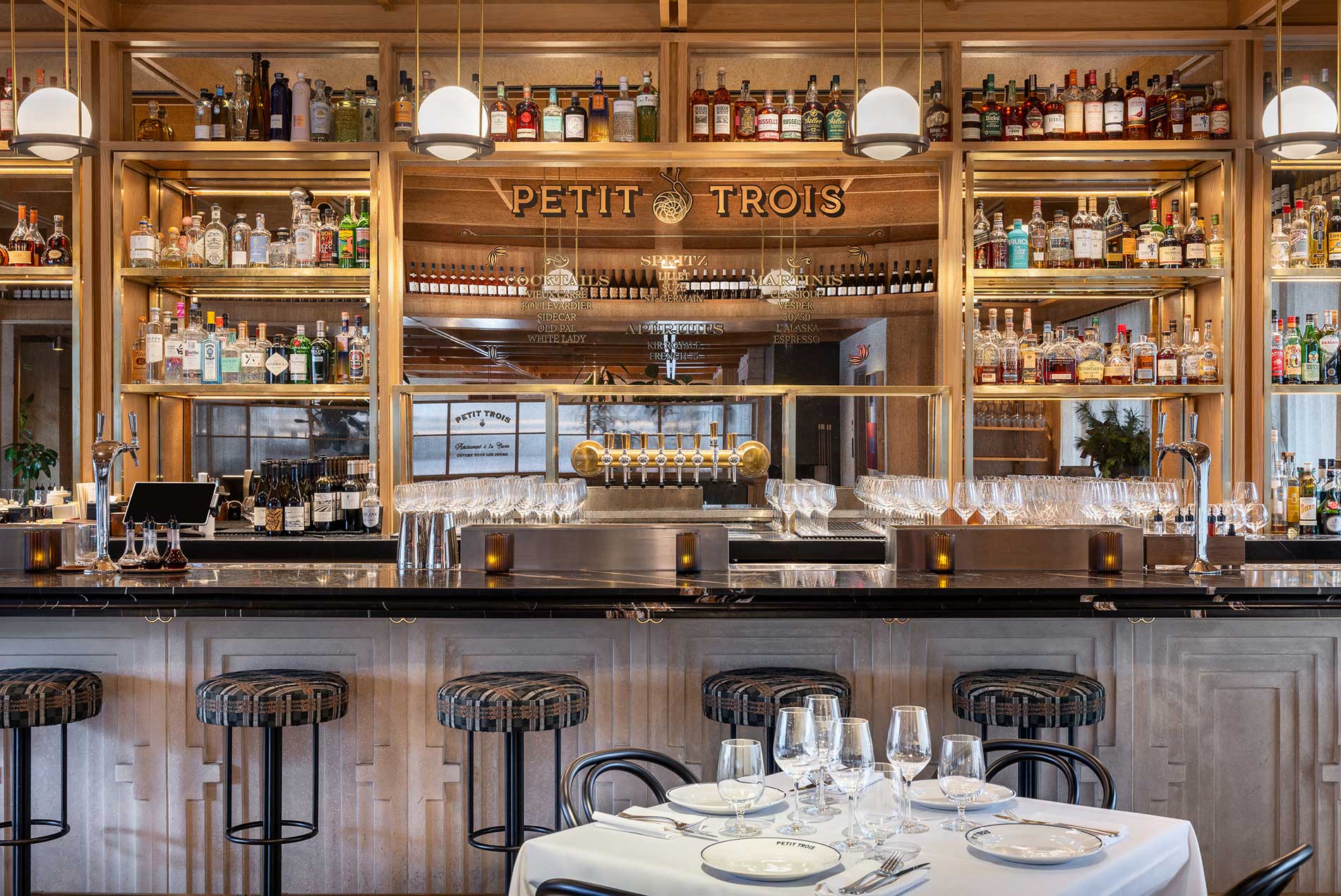 Petit Trois logo and lettering on the mirror at the bar at Petit Trois Aspen