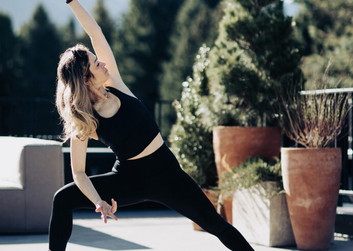 Instructor posing a yoga move on Roof Terrace